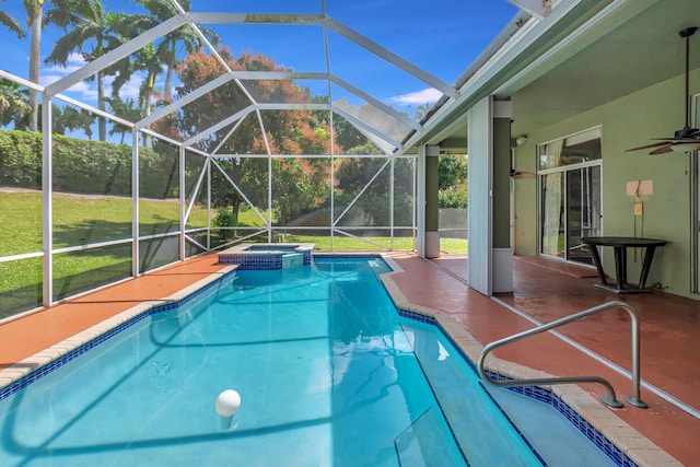 view of swimming pool with a ceiling fan, glass enclosure, a patio area, and a pool with connected hot tub