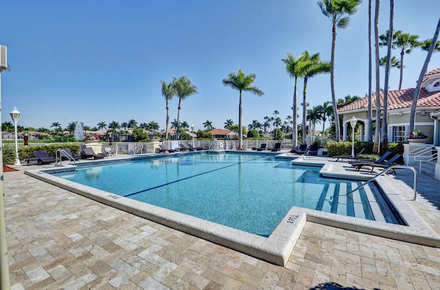 community pool featuring a patio and fence