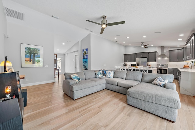 living area with lofted ceiling, recessed lighting, visible vents, and light wood-style floors