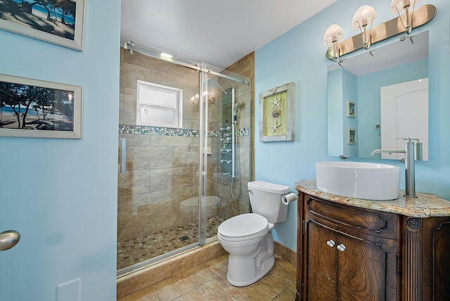 bathroom with toilet, tile patterned floors, a shower stall, and vanity