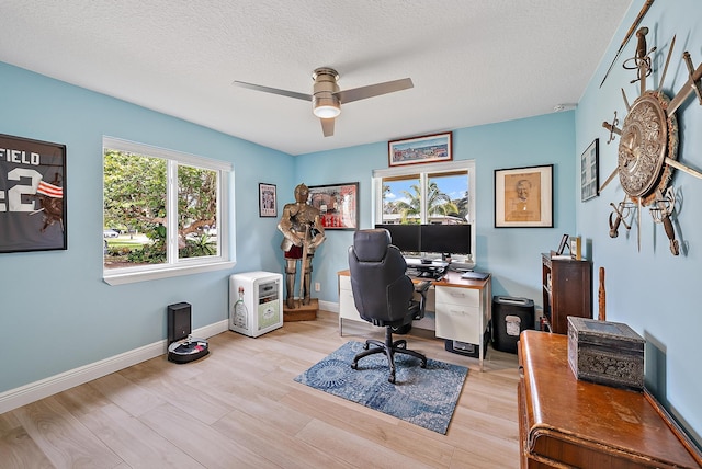 office featuring a ceiling fan, a textured ceiling, baseboards, and wood finished floors