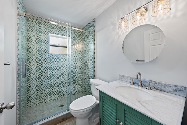 bathroom with vanity, a shower stall, and toilet