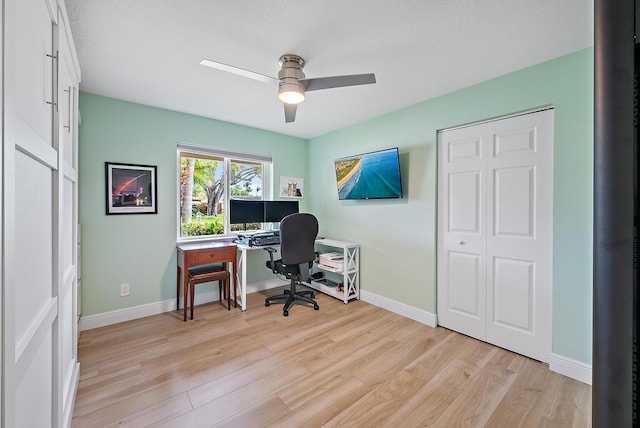 office featuring light wood-style floors, baseboards, and a ceiling fan