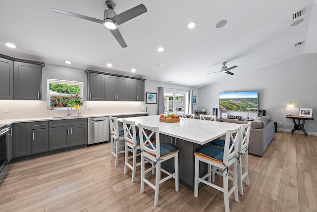 kitchen with dishwasher, a breakfast bar, plenty of natural light, and a sink