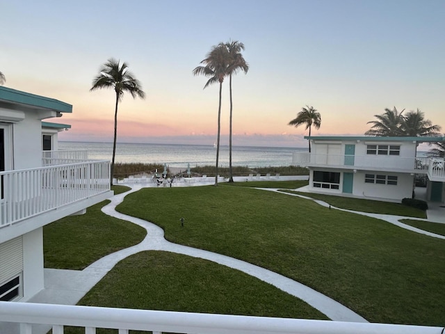 yard at dusk featuring a water view