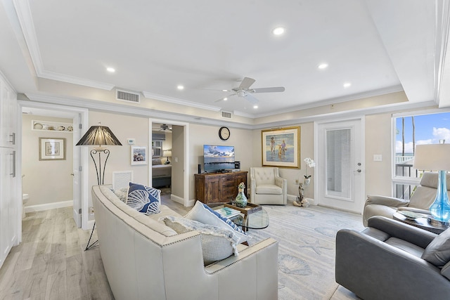 living room featuring ceiling fan, light wood finished floors, visible vents, and crown molding