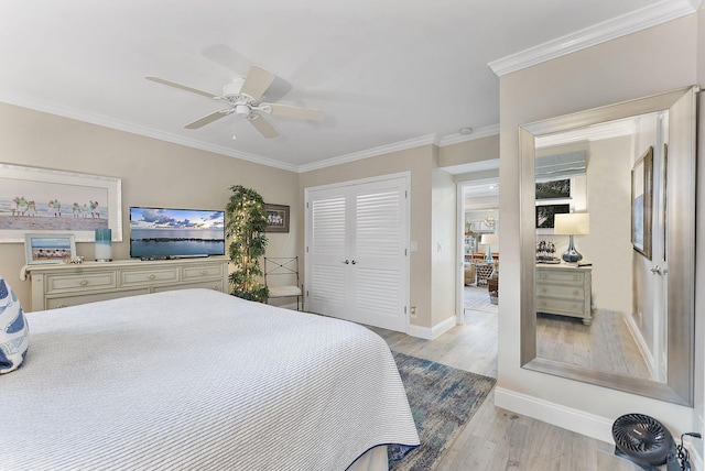 bedroom featuring baseboards, a ceiling fan, crown molding, light wood-type flooring, and a closet