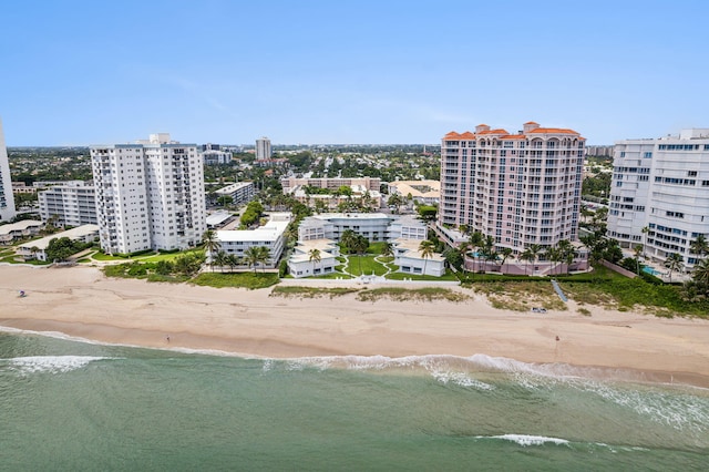 drone / aerial view featuring a view of the beach, a water view, and a view of city