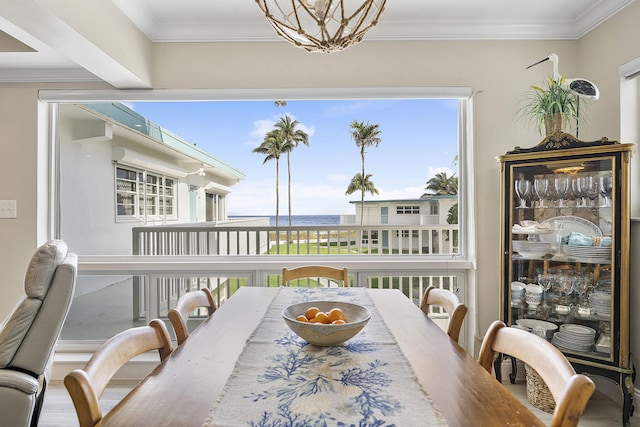 dining space with ornamental molding, a chandelier, and wood finished floors