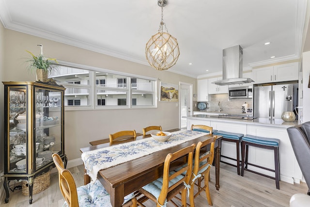 dining area featuring light wood-style flooring, ornamental molding, and recessed lighting