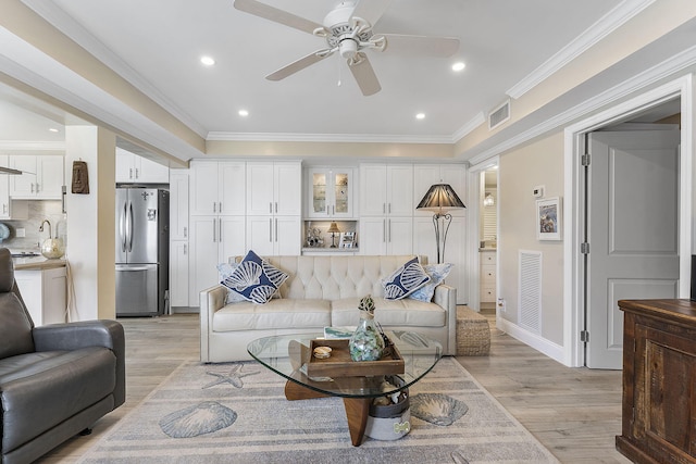 living room with light wood finished floors, recessed lighting, visible vents, and crown molding