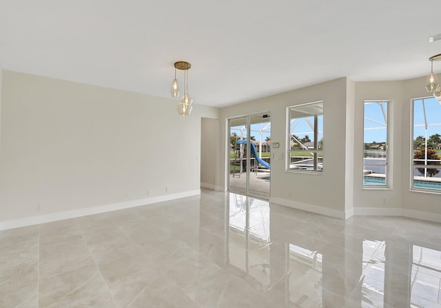 spare room with a wealth of natural light and baseboards