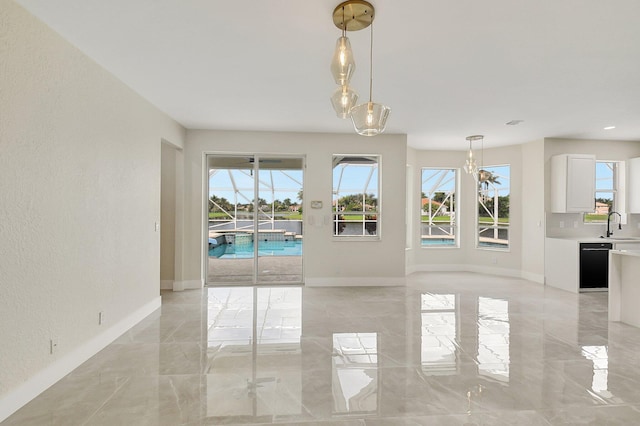 interior space featuring marble finish floor, plenty of natural light, and a sink