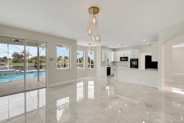 unfurnished living room with marble finish floor, baseboards, a sink, and recessed lighting