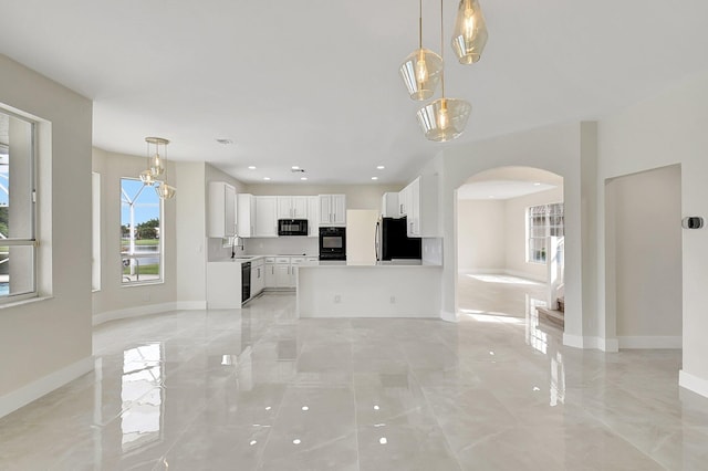 unfurnished living room with marble finish floor, baseboards, arched walkways, and a sink