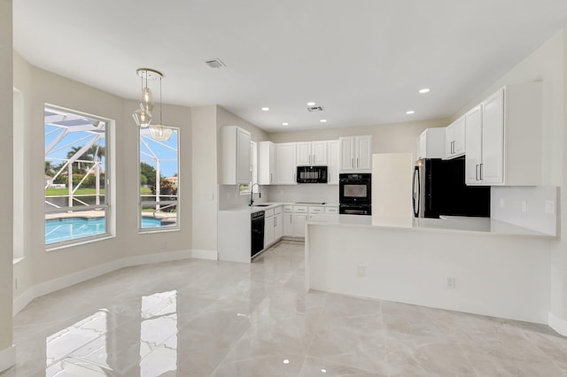 kitchen with visible vents, a peninsula, light countertops, black appliances, and a sink