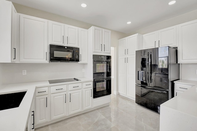 kitchen featuring black appliances, light countertops, and white cabinetry