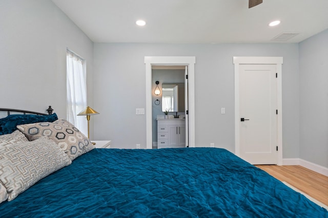 bedroom with baseboards, wood finished floors, visible vents, and recessed lighting