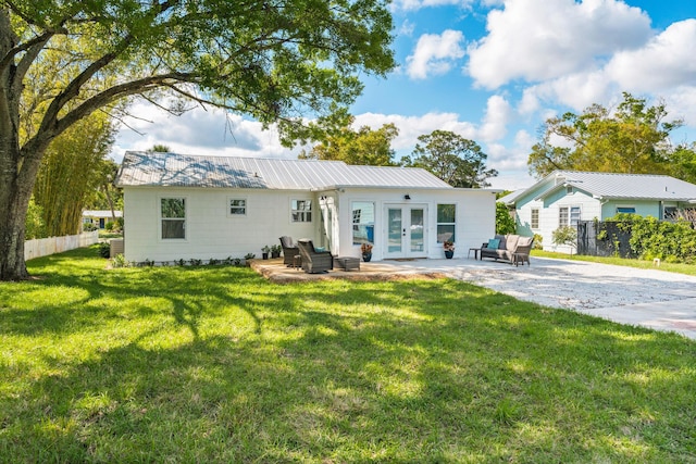 rear view of property featuring a patio area, fence, metal roof, and french doors