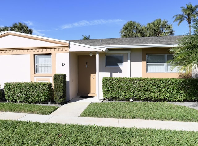 view of front of home with a shingled roof and stucco siding