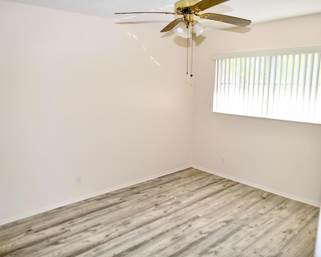 empty room featuring baseboards, a ceiling fan, and wood finished floors