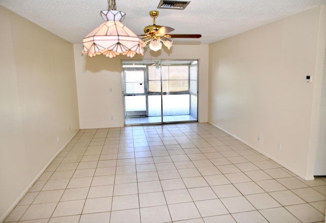 unfurnished room with light tile patterned floors, a ceiling fan, visible vents, and a textured ceiling