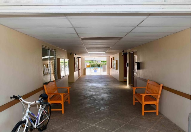 corridor with a paneled ceiling