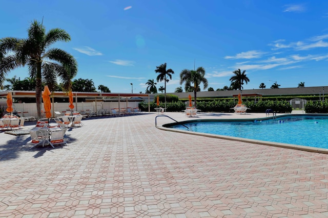 community pool with fence and a patio