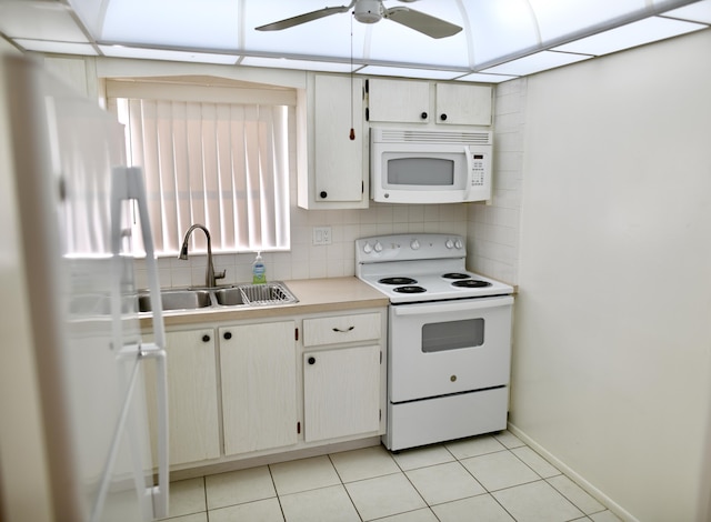 kitchen with white appliances, a sink, light countertops, backsplash, and light tile patterned flooring