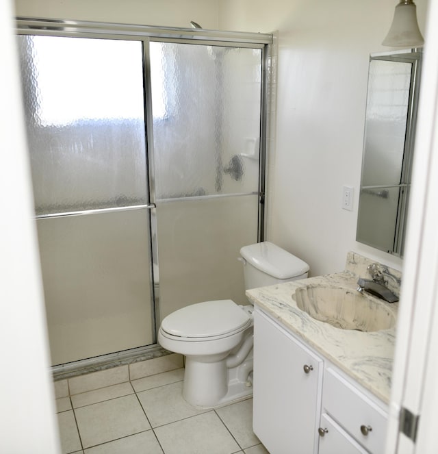 bathroom with vanity, a shower stall, toilet, and tile patterned floors