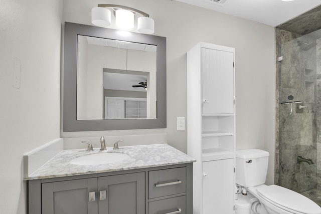 bathroom with a stall shower, visible vents, a ceiling fan, toilet, and vanity