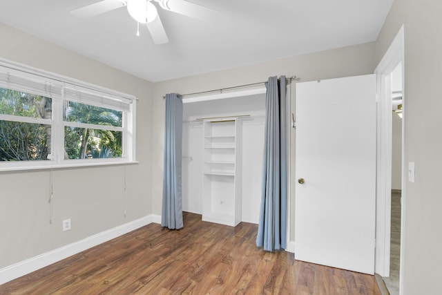 unfurnished bedroom featuring a ceiling fan, a closet, baseboards, and wood finished floors