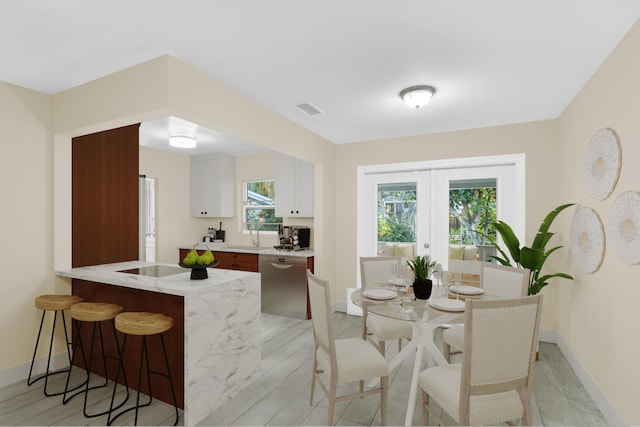 kitchen with visible vents, a breakfast bar, a peninsula, french doors, and stainless steel dishwasher