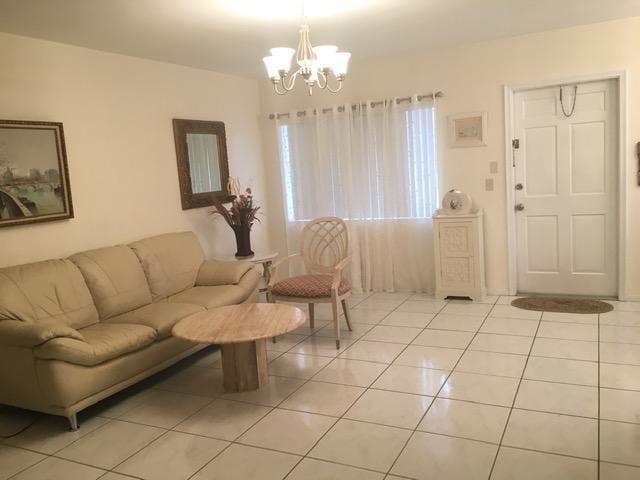 living room featuring light tile patterned flooring and an inviting chandelier