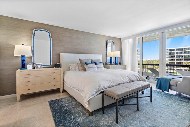 bedroom featuring access to exterior, baseboards, tile patterned floors, a wall of windows, and wallpapered walls