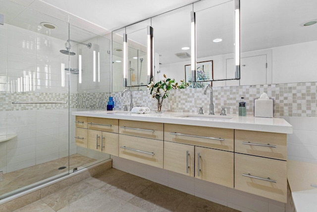 full bath with a stall shower, a sink, tile walls, and double vanity