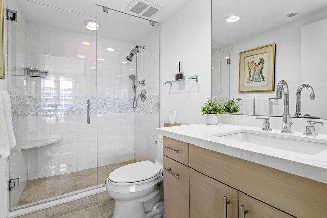 full bath featuring toilet, a shower stall, visible vents, and vanity