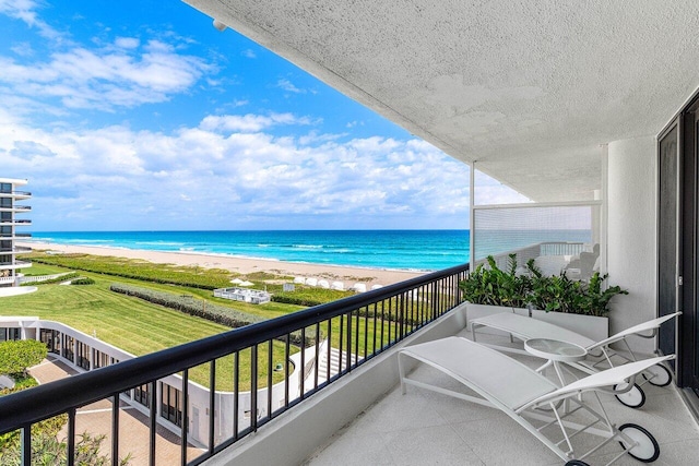 balcony featuring a water view and a beach view