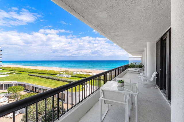 balcony with a water view and a beach view