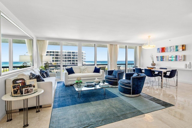 living area with baseboards, plenty of natural light, and a water view