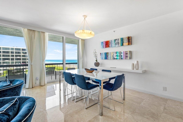 dining area with a water view and baseboards