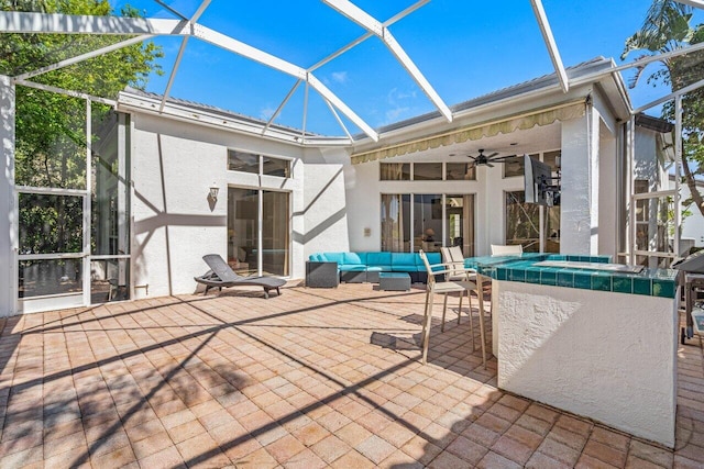 view of patio / terrace with a lanai, a swimming pool, a ceiling fan, and an outdoor living space