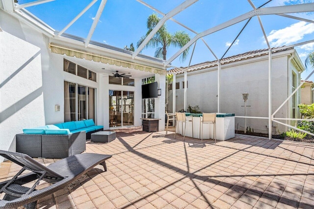 view of patio / terrace featuring a lanai, an outdoor living space, and ceiling fan