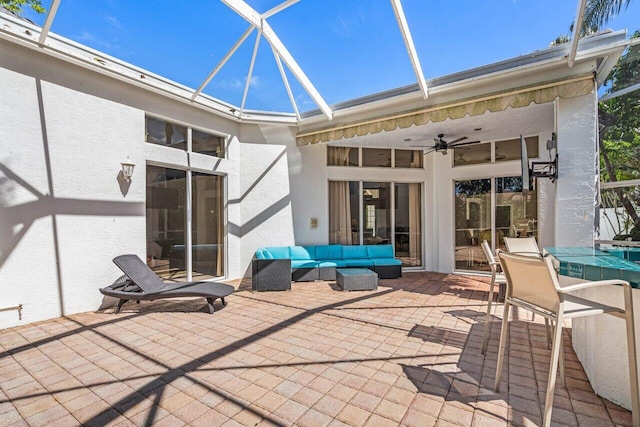 view of patio with glass enclosure, an outdoor hangout area, and a ceiling fan