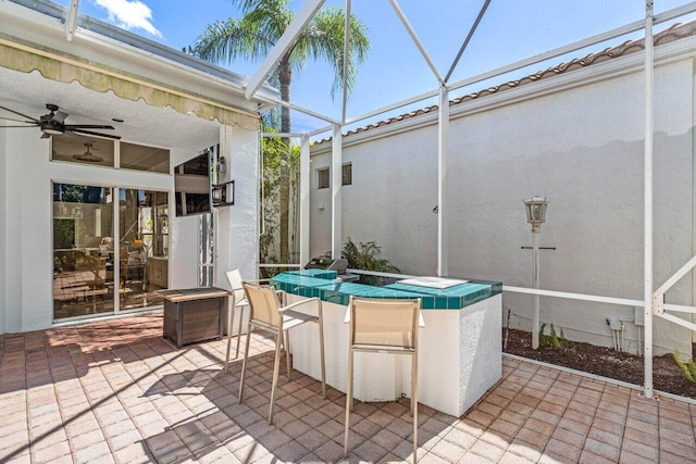 view of patio featuring glass enclosure and a ceiling fan