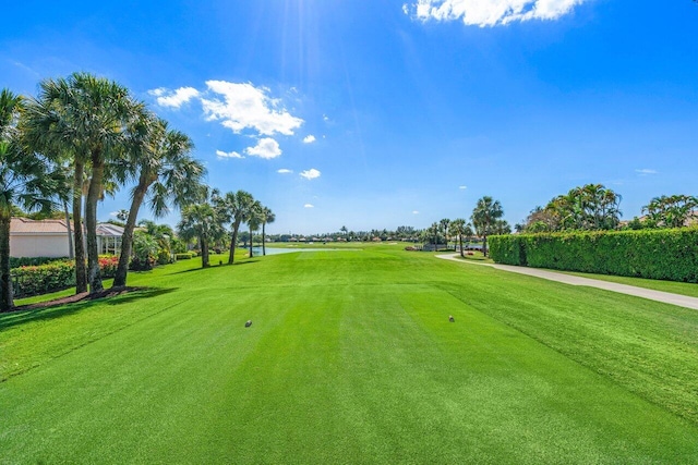 view of community with golf course view and a lawn