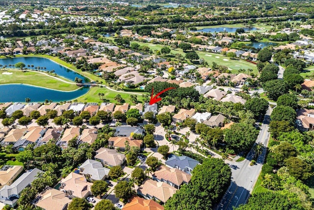 drone / aerial view with golf course view, a residential view, and a water view