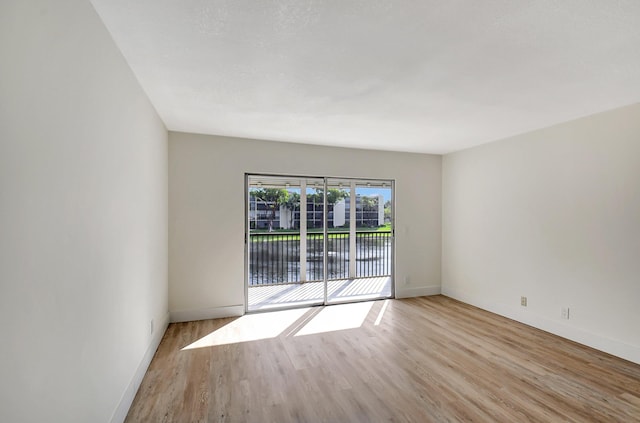 unfurnished room with light wood-style floors and baseboards