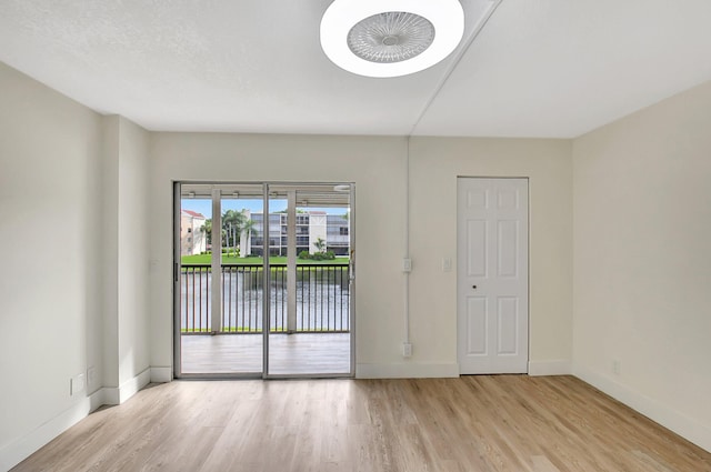 spare room with light wood-style floors and baseboards