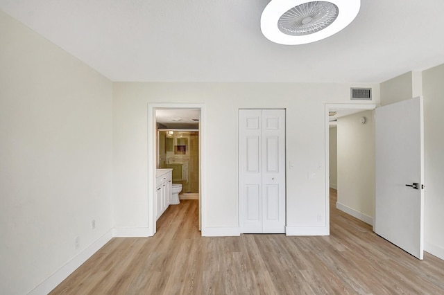 unfurnished bedroom with visible vents, baseboards, ensuite bathroom, light wood-type flooring, and a closet